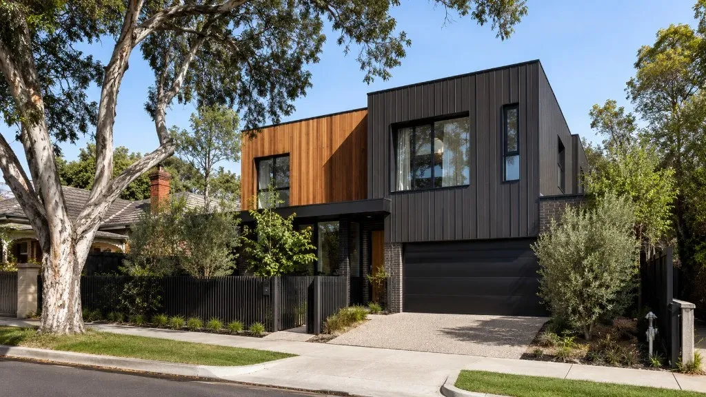 Modern Melbourne home with dark metal cladding, natural timber feature panels, and brickwork